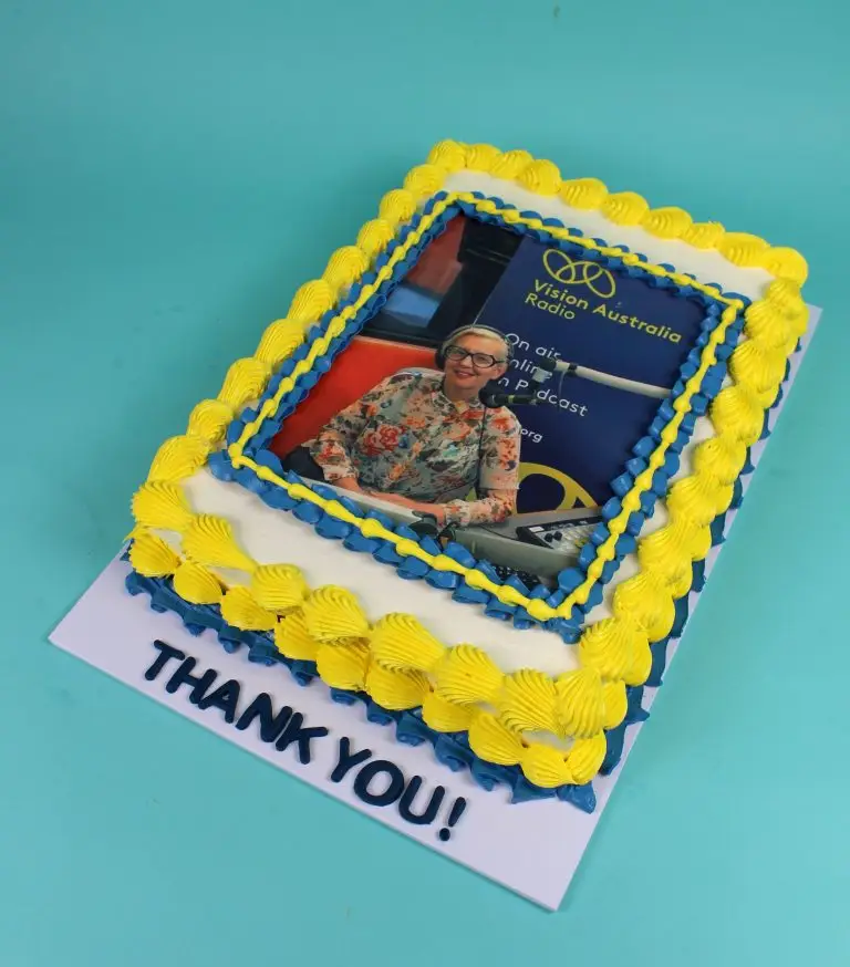 Cake decorated with yellow and blue icing featuring a photo and the words 'Thank You!' corporate cake, business launch, company cake, number cake. slab cake