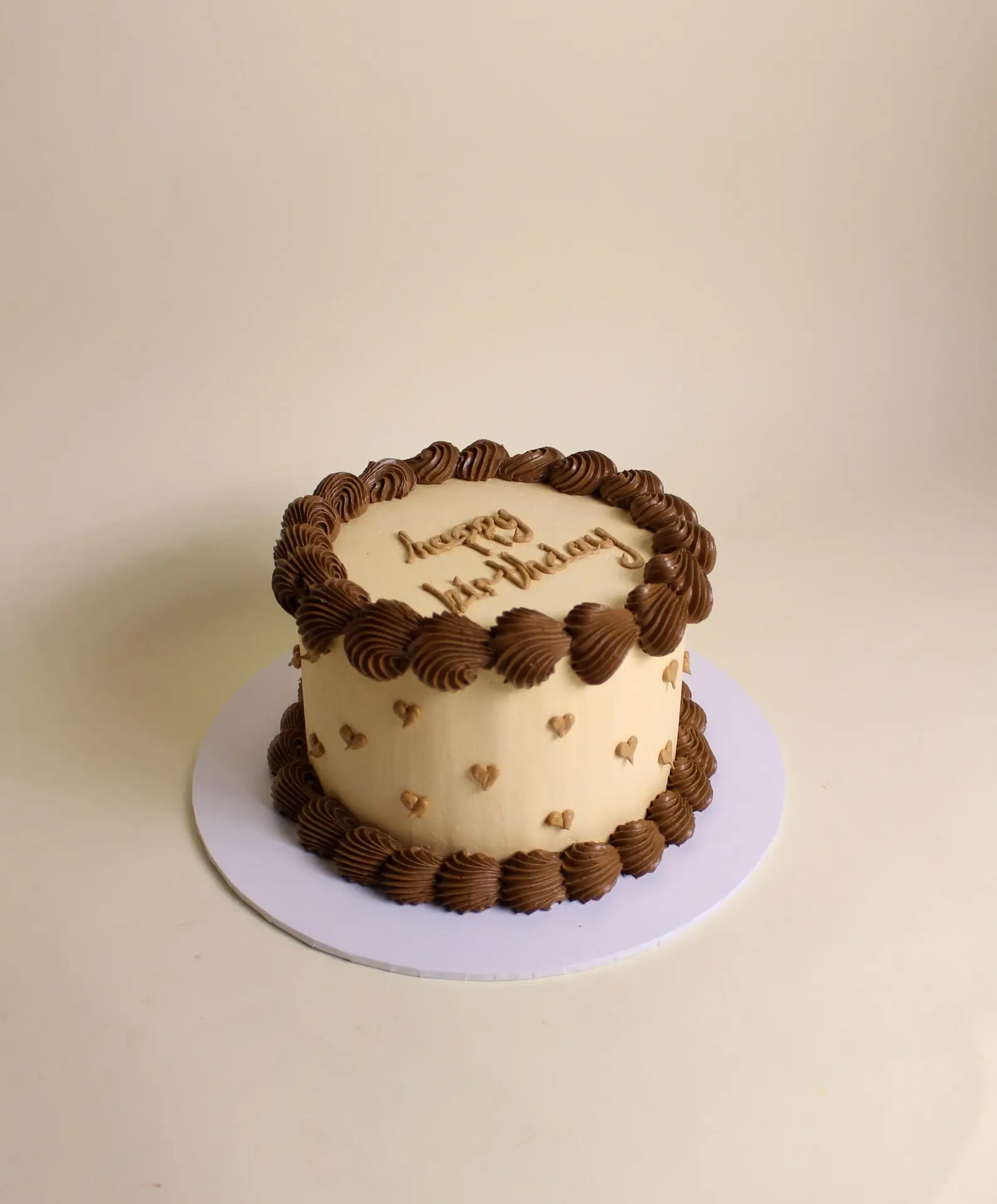 Round cake with chocolate frosting and decorative piping, featuring a 'Happy Birthday' inscription. love piping cake, vintage cake, retro cake, birthday cake , heart cake